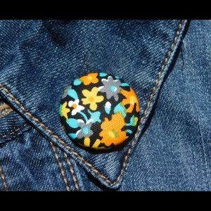 Bright floral lapel pin.